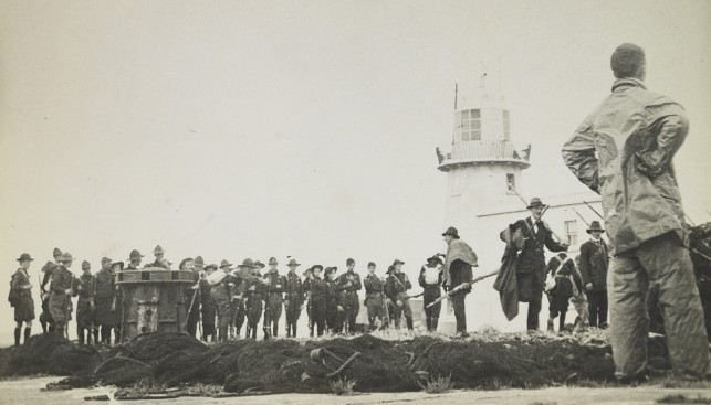 Эрскин Чайлдерс (стоит) спиной у маяка Хоута. Доставленные им винтовки уже в руках волонтеров. 1914 г.