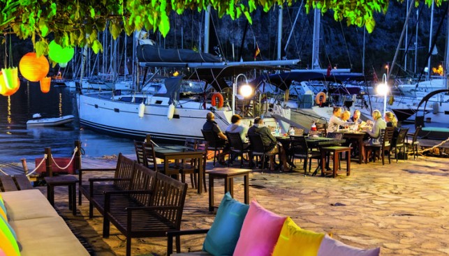Зона отдыха и столики рядом со стоянкой яхт в марине Cennet в Орхание 
